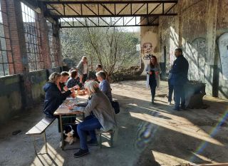 Erfgoed - Westerwolde - Bijeenkomst Meelfabriek, mensen lunchen aan een tafel.